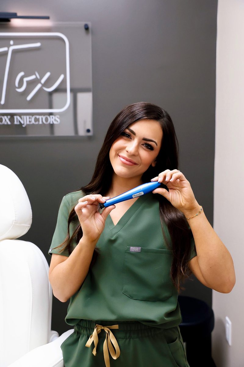 Paige Johnston RN holding FDA-cleared Rejuvapen NXT microneedling device at ICT Tox Wichita
